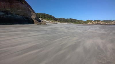 Wind treibt den Sand über den Strand